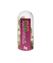 Glass container with a colorful label featuring text and patterns on a white background